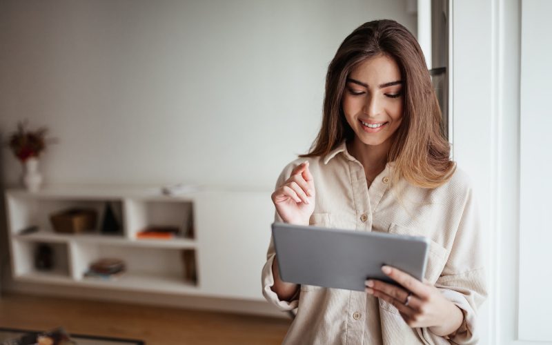 smiling-pretty-young-asian-lady-in-casual-use-tablet-for-control-smart-home-enjoy-study-and-work.jpg